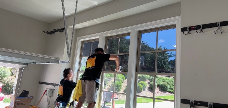 Joe and Evan from Sungate installing window film at a Tuxedo Park Atlanta home