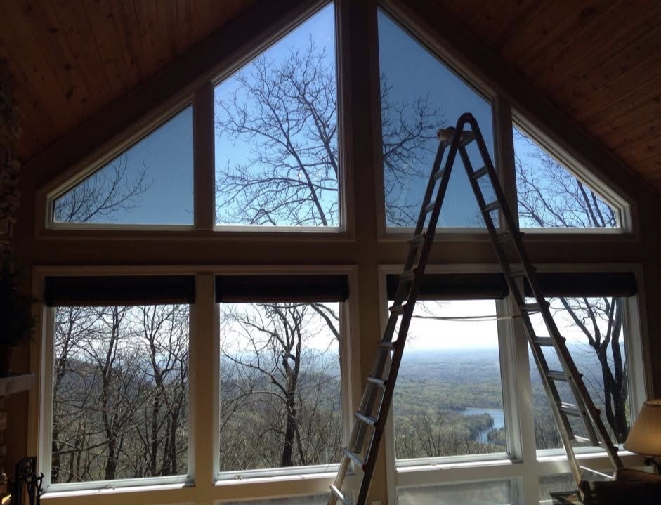 Mountain cabin cathedral windows with ladder during window film installation