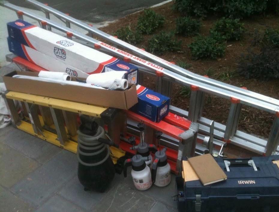 Window film rolls and installation tools laid out before a large commercial job