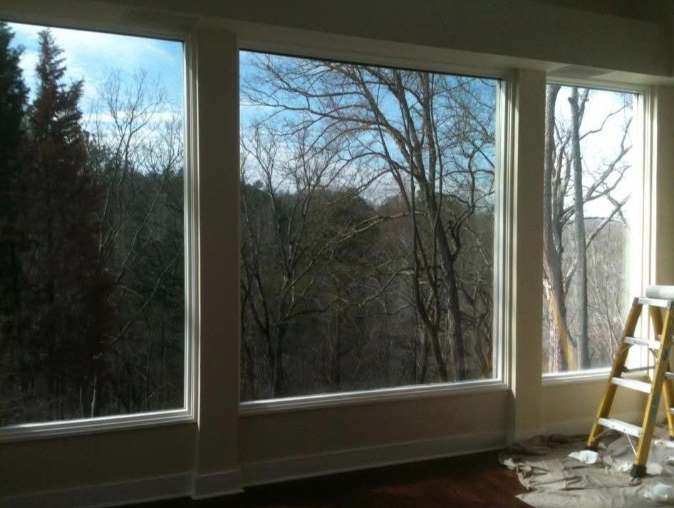 Large residential windows with forest view after window film installation