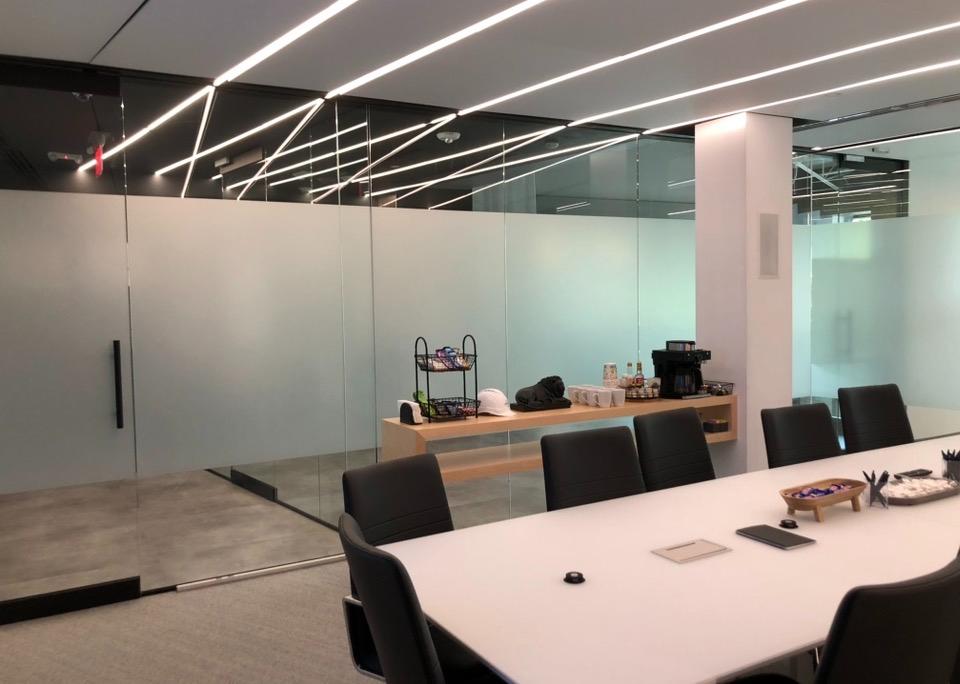 Modern conference room with dramatic ceiling lighting and frosted glass partitions