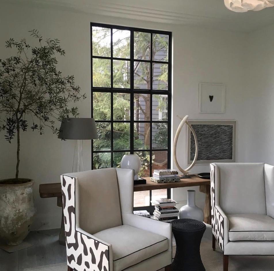 Elegant living room with tall black grid window and designer furniture