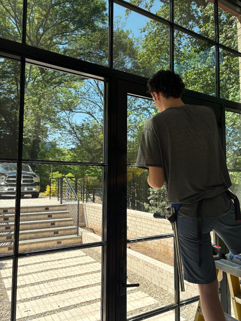 Evan installing Hüper Optik Ceramic 30 on arched stained glass window