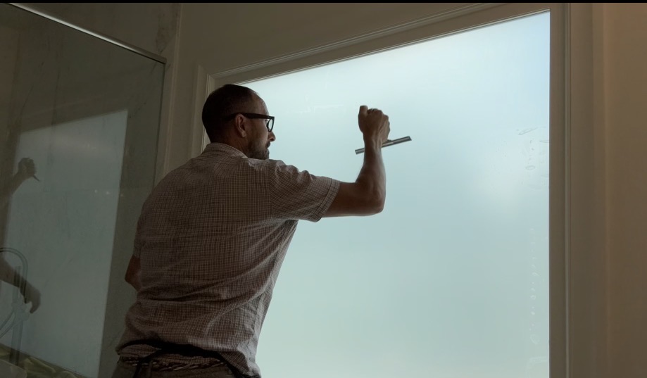 Joe Anderson installing window film at South on Main, Woodstock GA