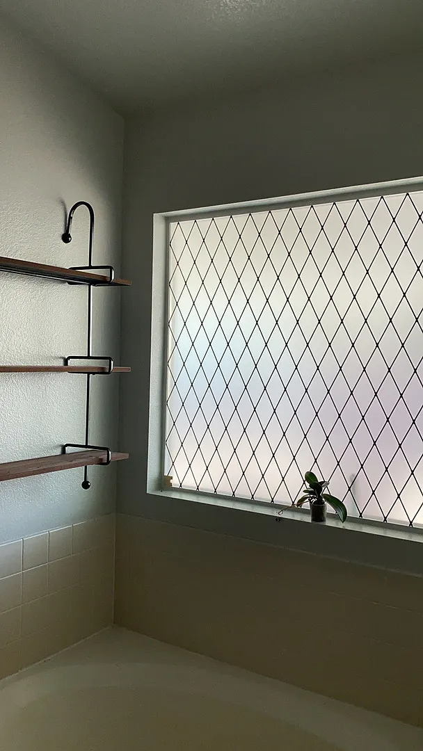 Bathroom window with sx-1550 Dusted Leaf decorative film glowing with warm backlight