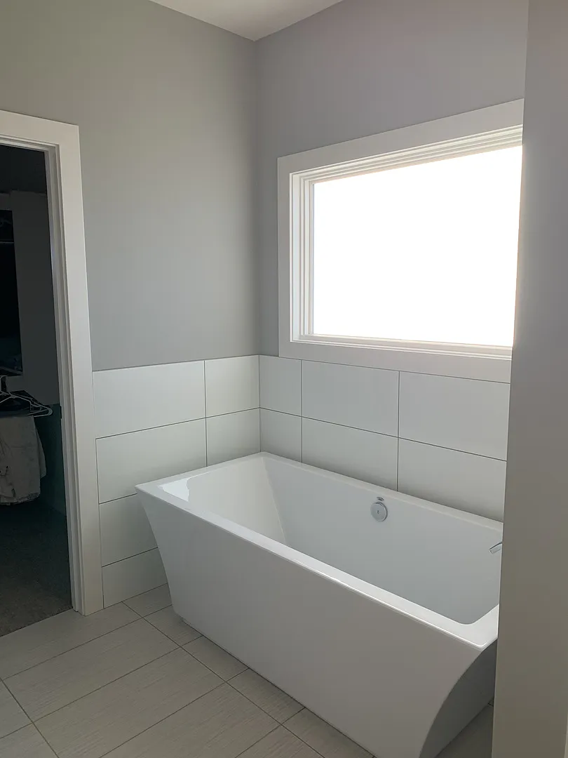 Modern freestanding bathtub with white frost privacy film on bathroom window