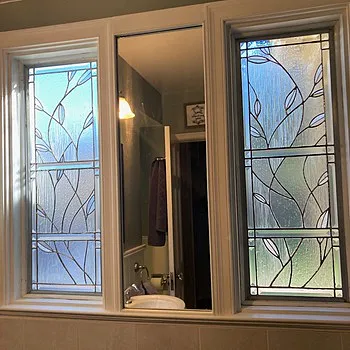 Bathroom windows with sx1 decorative leaf and vine pattern film beside vanity mirror